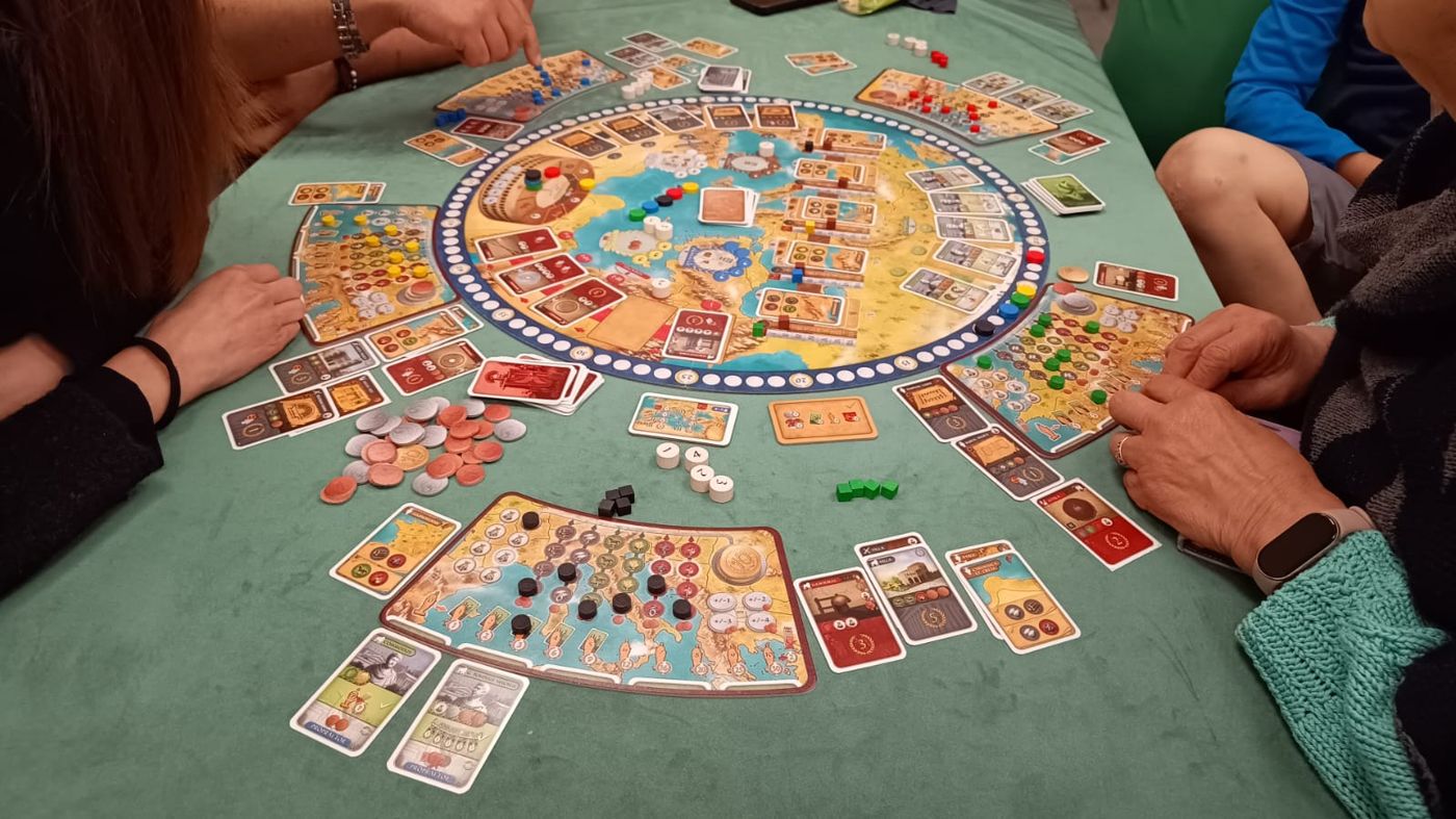 Mani di giocatori attorno a un tabellone
